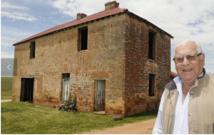 CONVICT HISTORY: Paul Hennessy with the 200-year-old two-storey convict barracks on Macquarie, the former home of Blue Mountains explorer William Lawson. Photo: CHRIS SEABROOK